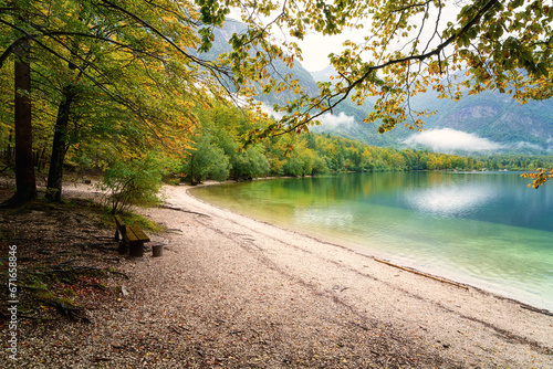 Bohinj lake  Bohinjsko jezero   Triglav national park  amazing autumn landscape  Slovenia. Scenic view of the clear water  Alps mountains with clouds and colored forest  outdoor travel background