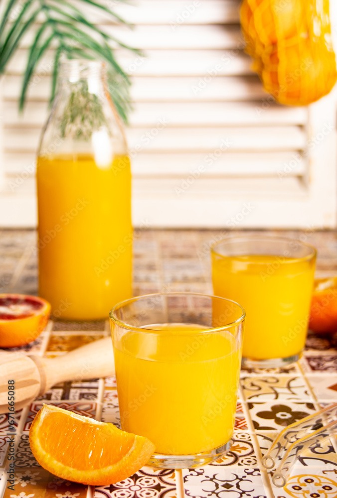 Fototapeta premium Fresh orange juice on table with slices fruits.