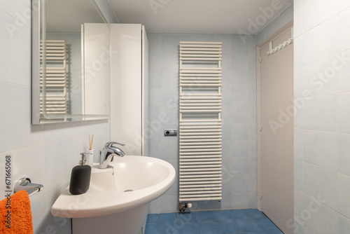 Radiator and cabinet in modern bathroom with vanity area