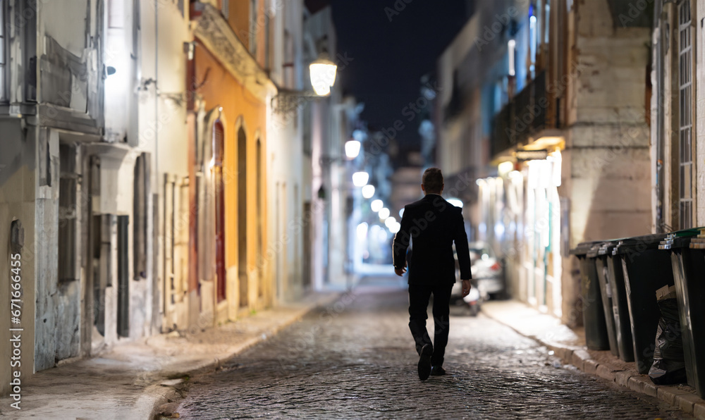 A person walking through the empty night street