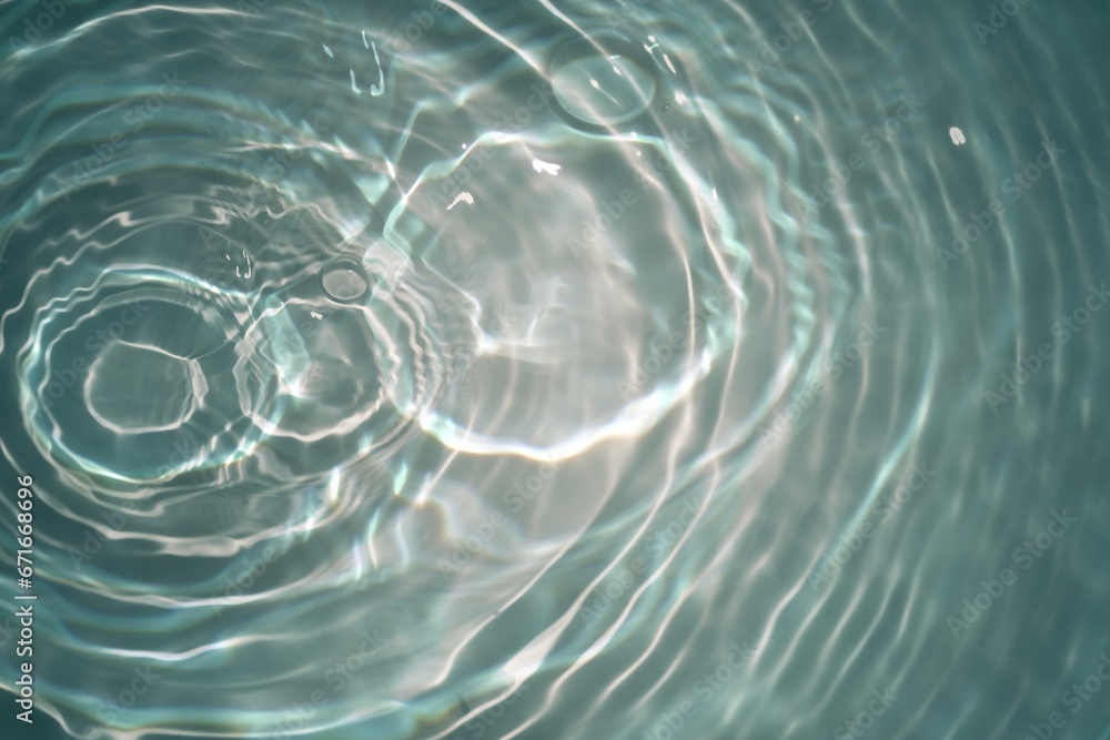 Defocus blurred transparent blue colored clear calm water surface texture with splashes reflection. Trendy abstract nature background. Water waves in sunlight with copy space. Blue watercolor shine. Defocus blurred transparent blue colored clear calm water surface texture with splashes reflection. Trendy abstract nature background. Water waves in sunlight with copy space. Blue watercolor shine.