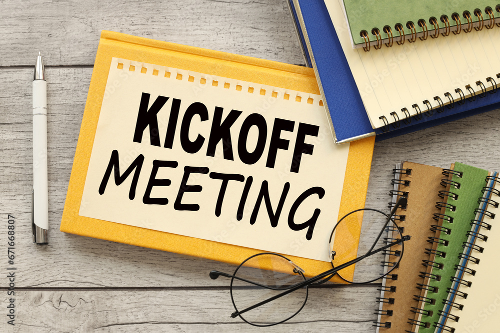 sheet of paper on a yellow notepad and glasses on the table. workbooks. text Kick-Off Meeting sheet of paper on a yellow notepad and glasses on the table. workbooks. text Kick-Off Meeting