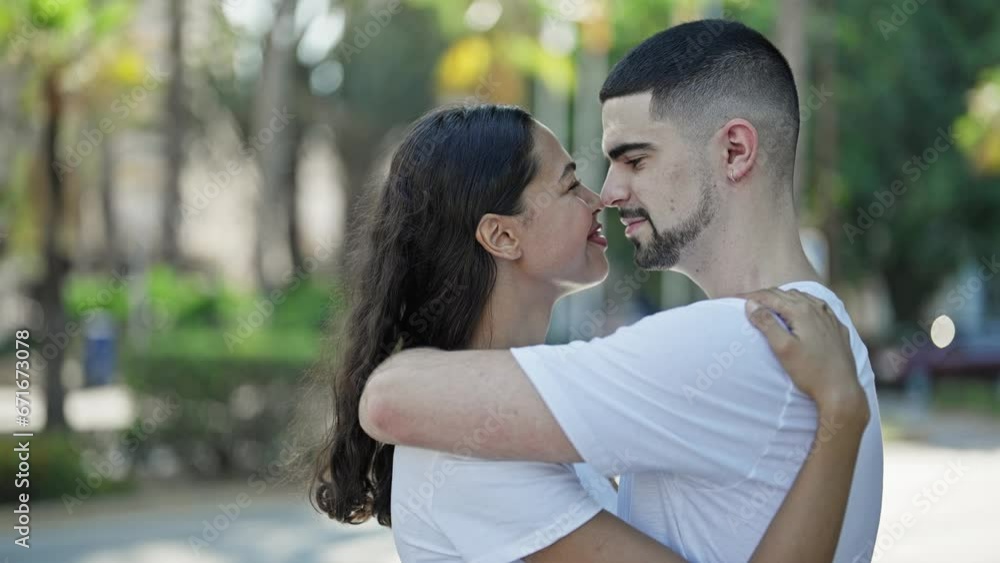 Confident, beautiful couple hugging and joyfully smiling in a sunny park, expressing love and happiness while enjoying a casual, outdoor lifestyle. Confident, beautiful couple hugging and joyfully smiling in a sunny park, expressing love and happiness while enjoying a casual, outdoor lifestyle.