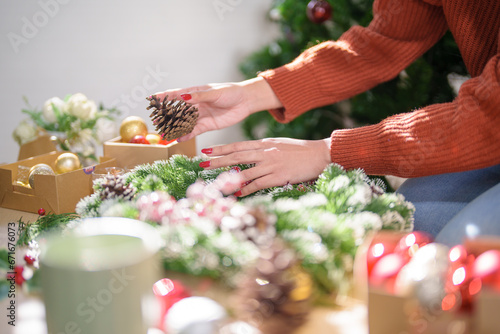 Woman making mistletoe wreath Christmas wreath decoration with hand made DIY winter greenery florist hands making Christmas wreath beautiful mistletoe.