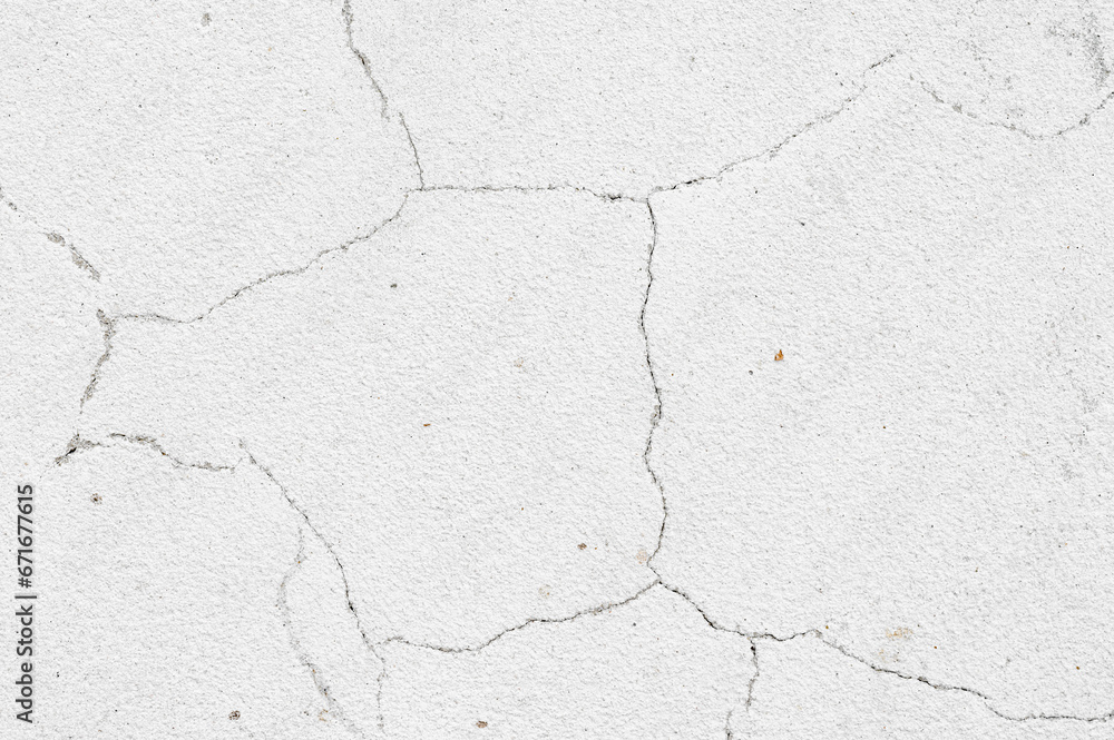 Fototapeta premium An old white wall with a cracked texture is decorated with cement mortar