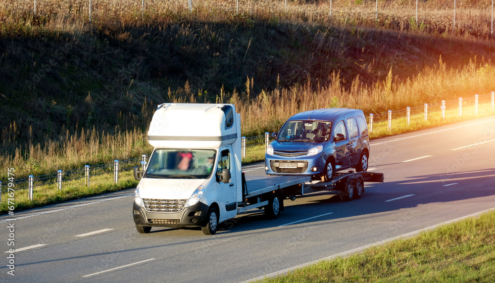 A side view of the tow truck with a damaged commercial vehicle after being in a traffic accident. Emergency roadside assistance. A side view of the tow truck with a damaged commercial vehicle after being in a traffic accident. Emergency roadside assistance.