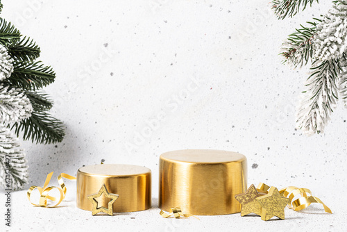 Golden cosmetic podiums and Christmas decorations on white stone background. Cosmetic brending concept. photo