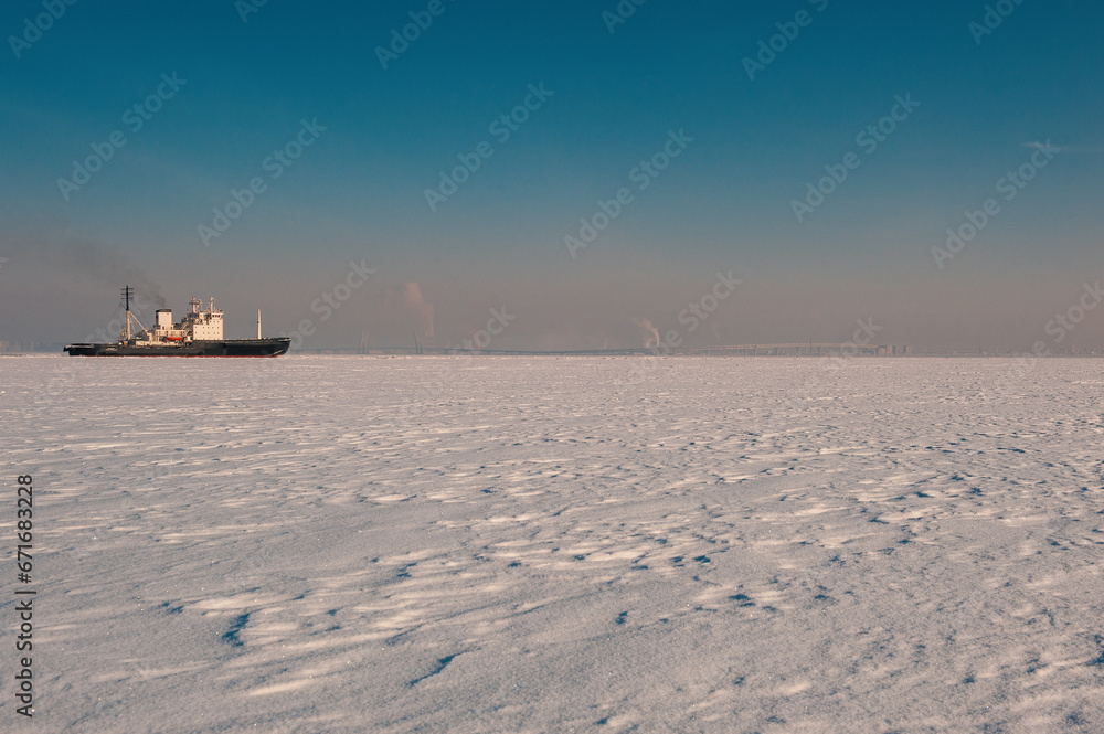 Winter shipping. Big cargo ship in frozen sea fairway Winter shipping. Big cargo ship in frozen sea fairway