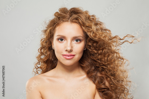 Perfect wavy hair woman. Young fashion model with long curly hairstyle and natural fresh clear skin posing on white background