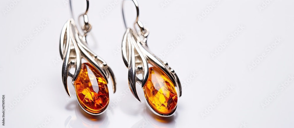 Amber earrings in silver captured alone on a white backdrop Amber earrings in silver captured alone on a white backdrop