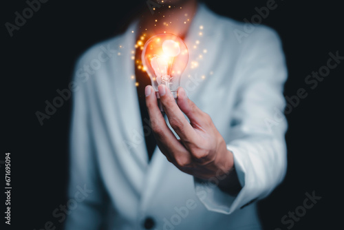 Businessman holding a light bulb creates new ideas. Innovation. Brainstorming. Solutions. And inspiration. Imagination. Creativity. Problem solving. Solution removing obstacles to success in business.