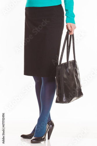 Hand of an elegantly dressed woman holding black bag. White background