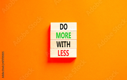 Do more with less symbol. Concept word Do more with less on beautiful wooden block. Beautiful orange table orange background. Business do more with less concept. Copy space.