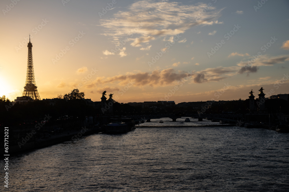 sunset over the river with a silhouette of the Eiffel tower