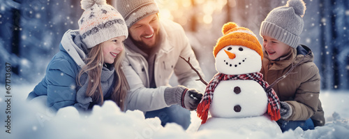 Family making a snowman in snowy forest. Concept of the relation and weekend together. photo