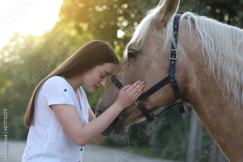 Beautiful woman with adorable horse outdoors. Lovely domesticated pet