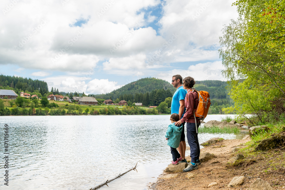 Heterosexual couple with their little daughter having a hiking day around schluchsee lake in Black Forest, Germany.