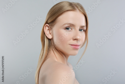 Portrait of beautiful young woman on grey background