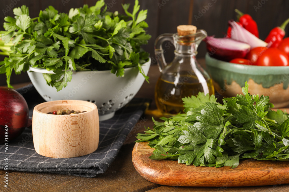 Fresh green parsley and different products on wooden table, closeup
