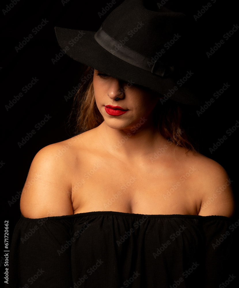 High contrast portrait of an attractive caucasian woman wearing black hat. Headshot of an adult