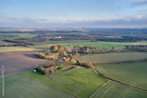 Drone point of view of private farming estate growing rye, wheat and sunflowers in remote farms and fields in Jutland, Denmark. Scenic aerial landscape of agriculture in green and serene countryside © Dhoxax/peopleimages.com
