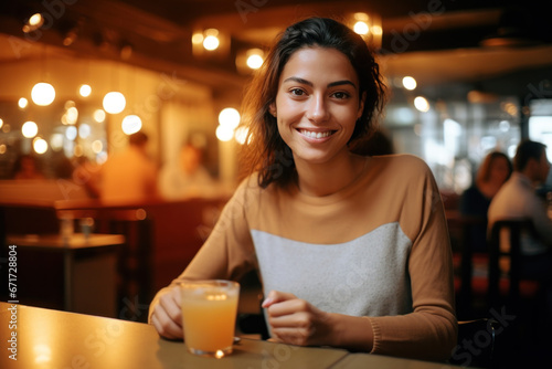 jeune femme attabl  e dans un restaurant souriante  ambiance chaleureuse