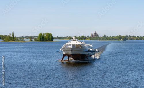 Tourist motor ship Meteor hydrofoils floating on Lake Onega against the background of the Kizhi Historical Park photo