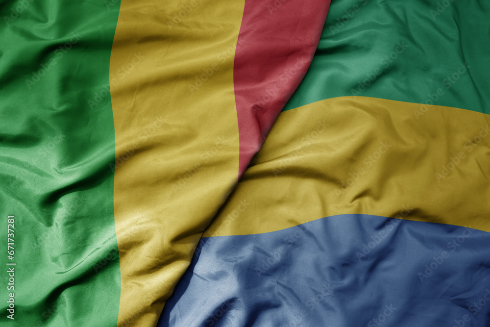 big waving national colorful flag of mali and national flag of gabon .