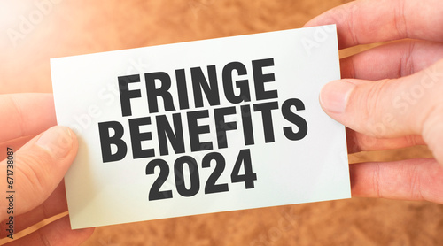 FRINGE BENEFITS 2024 word inscription on white card paper sheet in hands of a businessman.