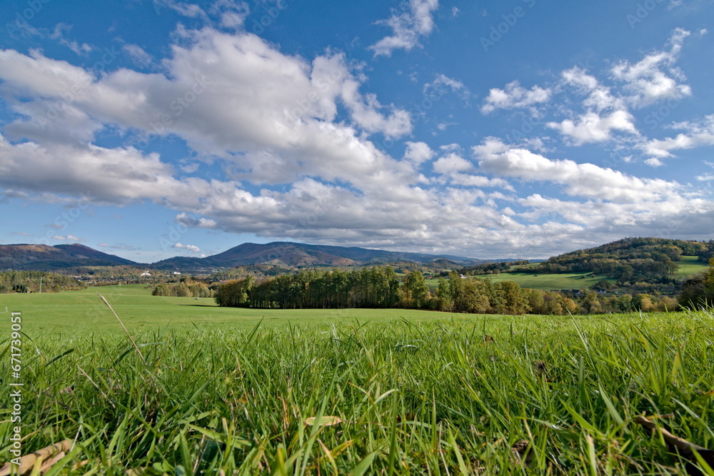 Radhost mountain and surrounding hills near to Roznov pod Radhostem, lovely small town in Czech republic. Landscape with fields, pastures and meadows and cloudy blue sky. Sunny autumn day.