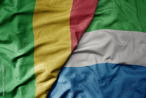 big waving national colorful flag of mali and national flag of sierra leone .
