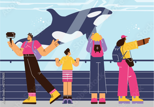 People in oceanarium watching dolphin and making photos.