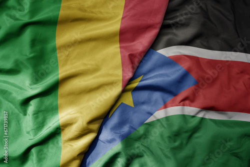 big waving national colorful flag of mali and national flag of south sudan .