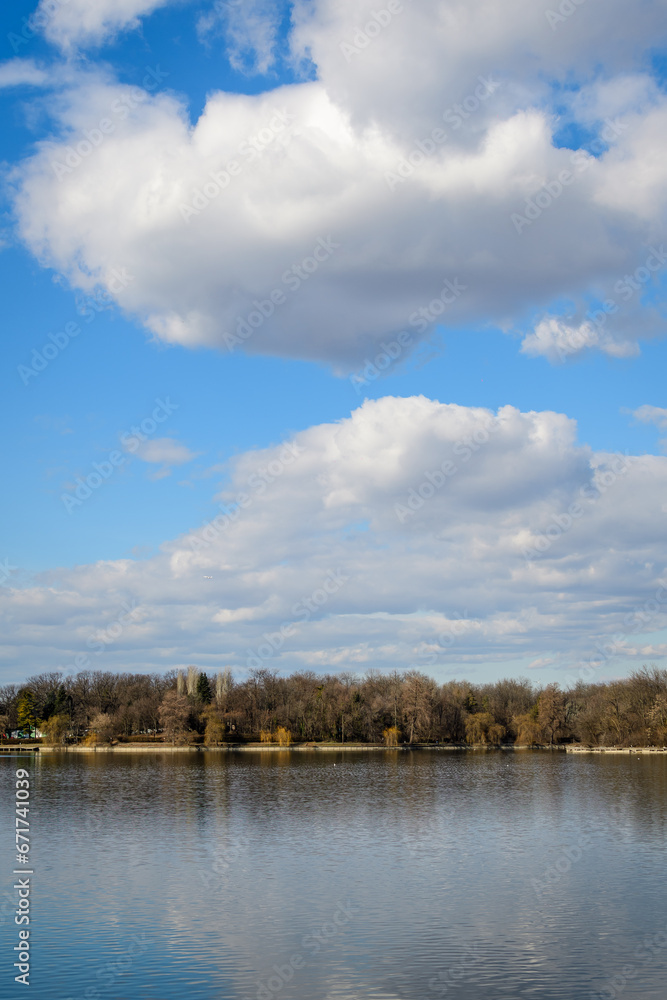 Landscape with large old trees near Herastrau lake in King Michael I Park (Herastrau) in Bucharest, Romania, in a sunny winter day