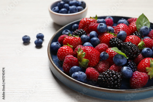 Different fresh ripe berries on light wooden table  closeup. Space for text