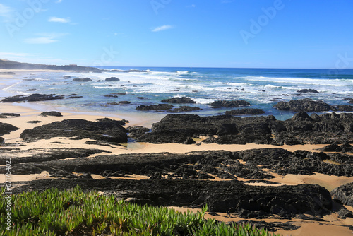 Beautiful Almograve beach with black basalt rocks in Portugal photo