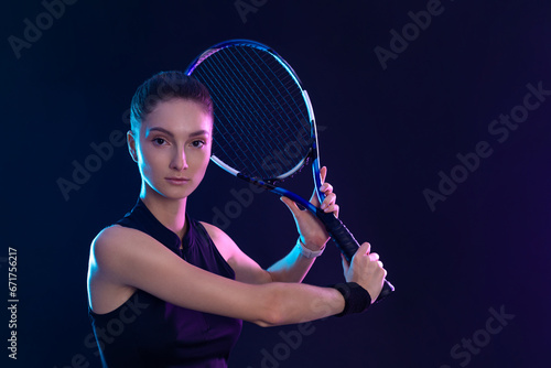 Tennis player with racket on tournament. Girl athlete with tenis racket on court with neon colors. Sport concept. Download a high quality photo for design of a sports app or tour events. © Mike Orlov