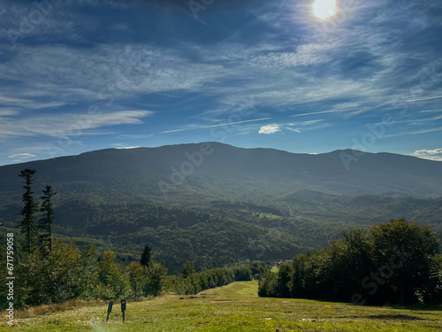 View from the slope of Mosorna Gron in Zawoja, Poland towards the peak of Babia Gora in Beskid Zywiecki. Sun over the mountains