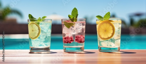 Refreshing poolside cocktails with a mojito and gin and tonic lemonade served chilled at the pool bar photo