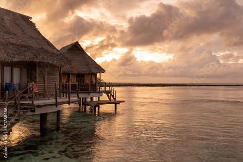French Polynesia Tikehau atoll. Beautiful sunrise over the coral reef lagoon seen from overwater bungalows. photo