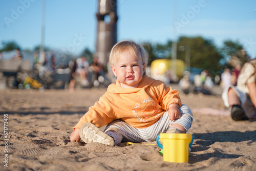 Cute little girl kid plays on the beach of St. Petersburg at sunset