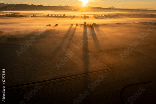 Dramatic sunrise over rural farmland with ground fog adding atmosphere. Morning in the Skagit Valley is an almost magical event as the color and texture make for a beautiful landscape. Washington, USA