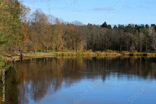 .river bend in autumn on a sunny day with trees in the distance