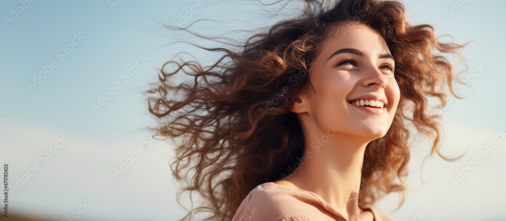 A youthful woman outdoors with a cheerful expression on her face and gazing in a different direction A youthful woman outdoors with a cheerful expression on her face and gazing in a different direction