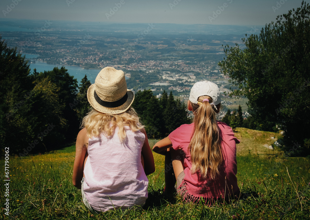 Obraz na płótnie dziewczynki siedzące na wzgórzu patrzące w dal w salonie