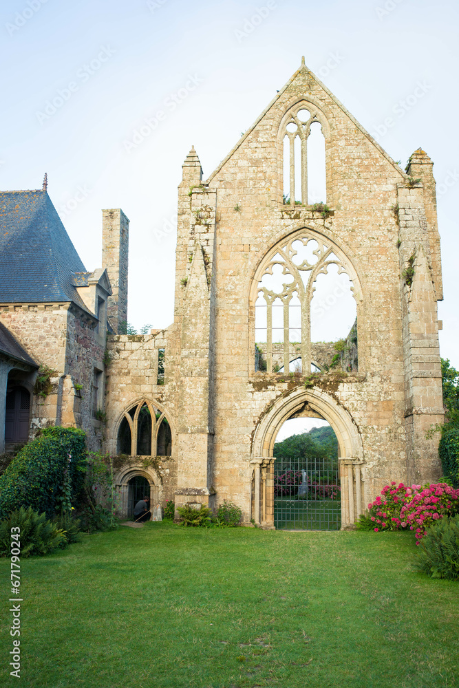 The main facade of Beauport Abbey, a roofless gothic building located in Paimpol, Cotes d'Armor, Brittany, France. August 2023, sunset view. vertical shot.