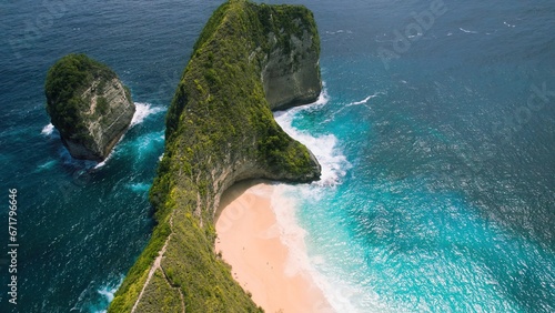 Pristine sandy Kelingking Beach on Nusa Penida island Bali. Turquoise ocean water by green cliffs.