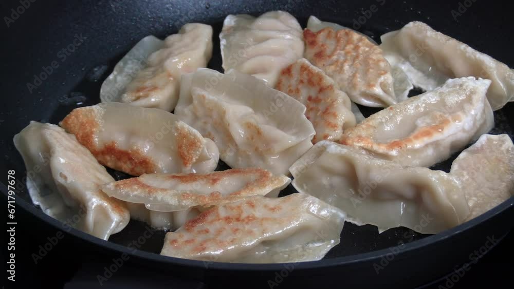 plusieurs gyoza dorés servi dans une poêle plusieurs gyoza dorés servi dans une poêle