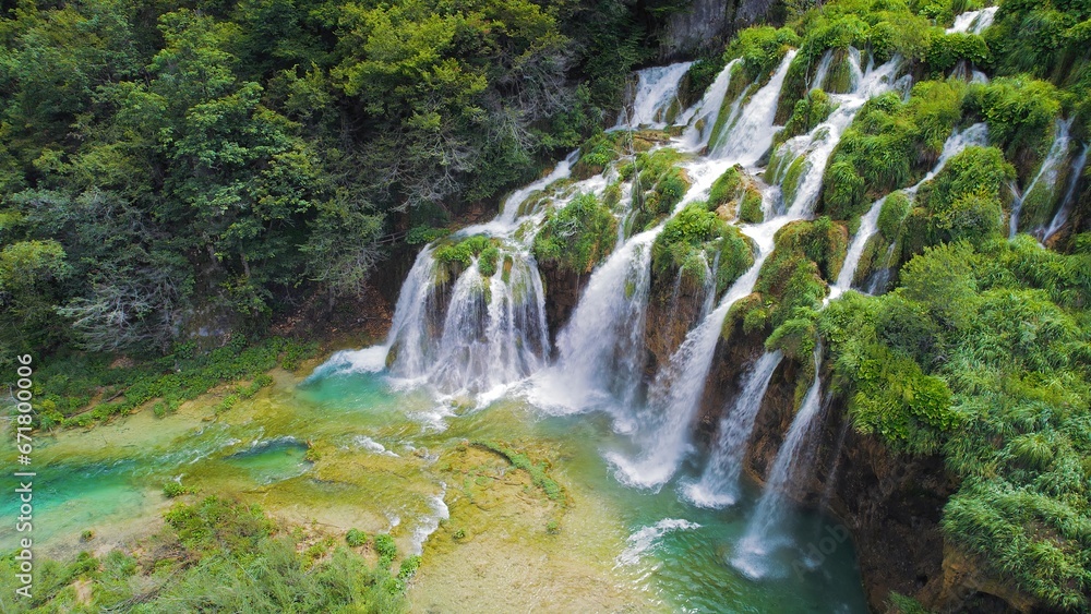 Obraz premium Beautiful waterfalls in summer National Park. Scenic mountain streams flow into a lake with aquamarine clear water. Summer landscape.