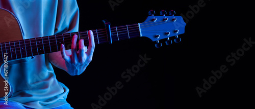 Playing the guiter in  black background amidst the lights and sounds, a hobby in life photo